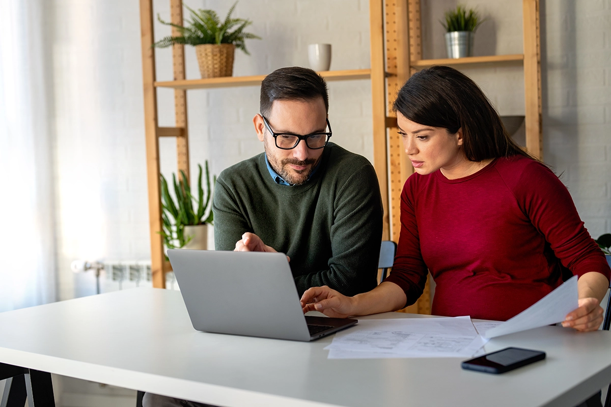 Couple completing ETF tax paperwork together on a laptop at home.