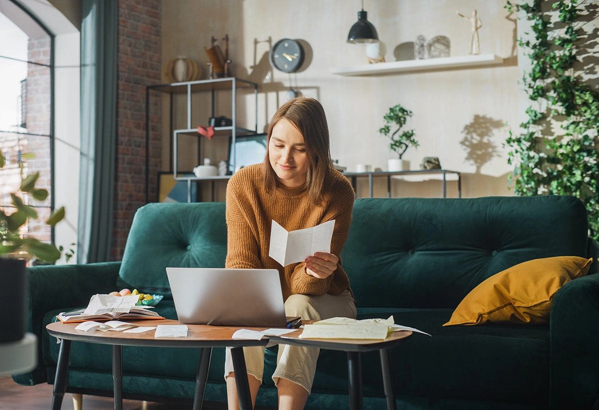 Woman on laptop at home researching investment gains tax