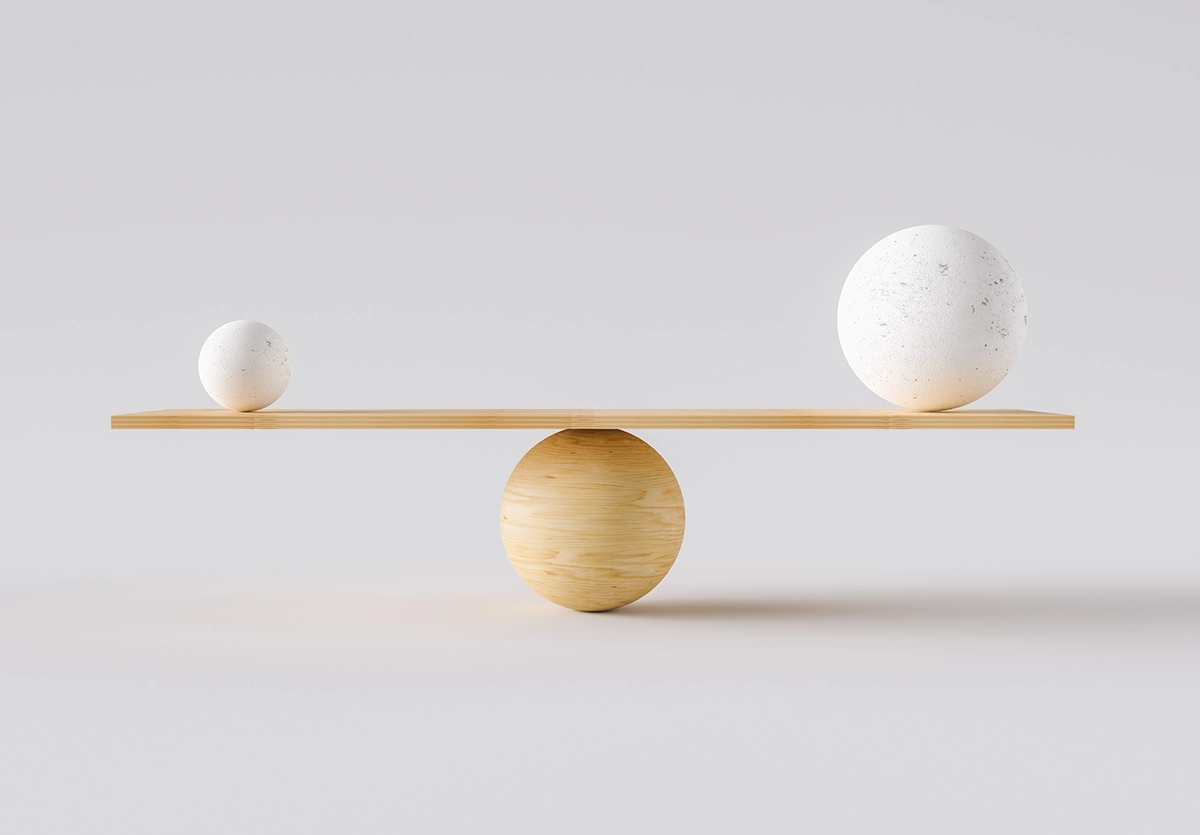 Balance holding a big white ball and a smaller ball symbolising finding a balance in the mix of investments.